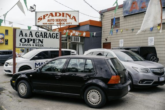Cars parked in front of an auto service garage with a sign reading "OPEN"