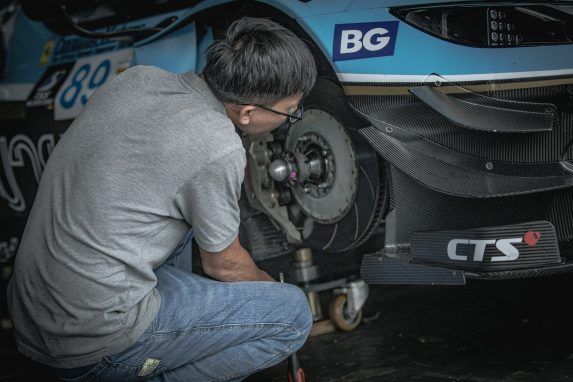 Mechanic working on a race car's brake system